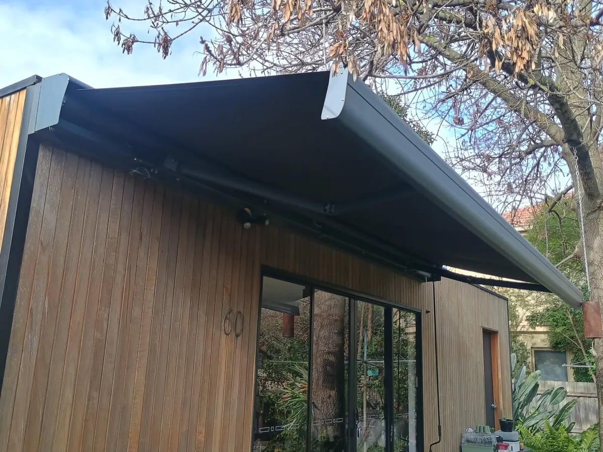 Charcoal folding arm awning extended over sliding doors, Melbourne