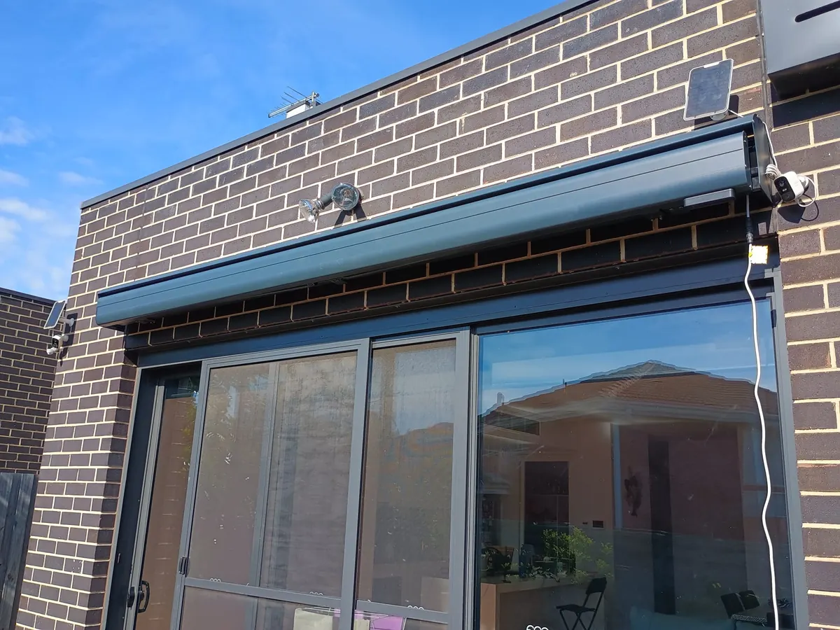 Motorised folding arm awning cassette above a sliding door, Melbourne